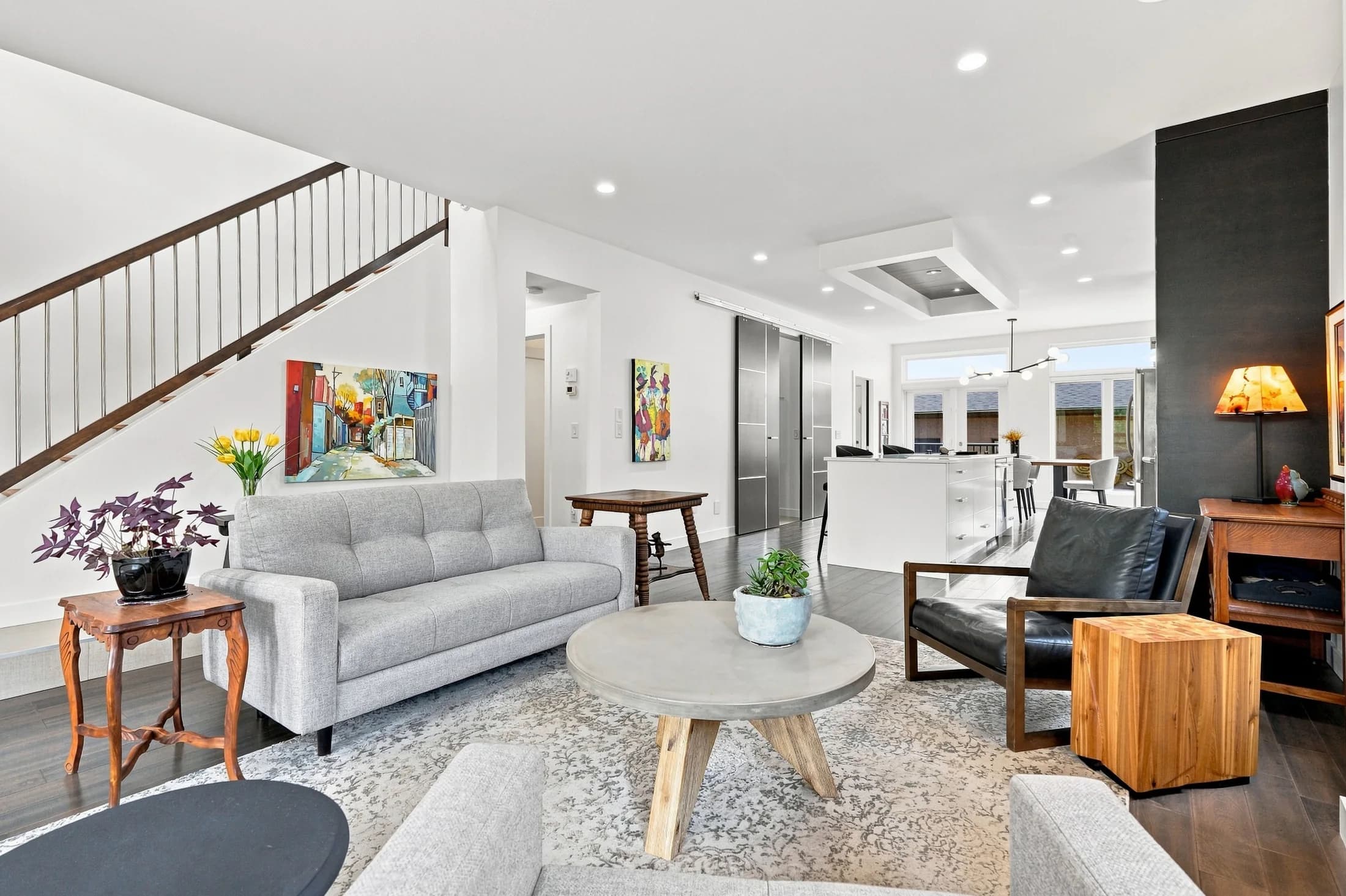 Living room with a patterned rug, wood furniture and large windows
