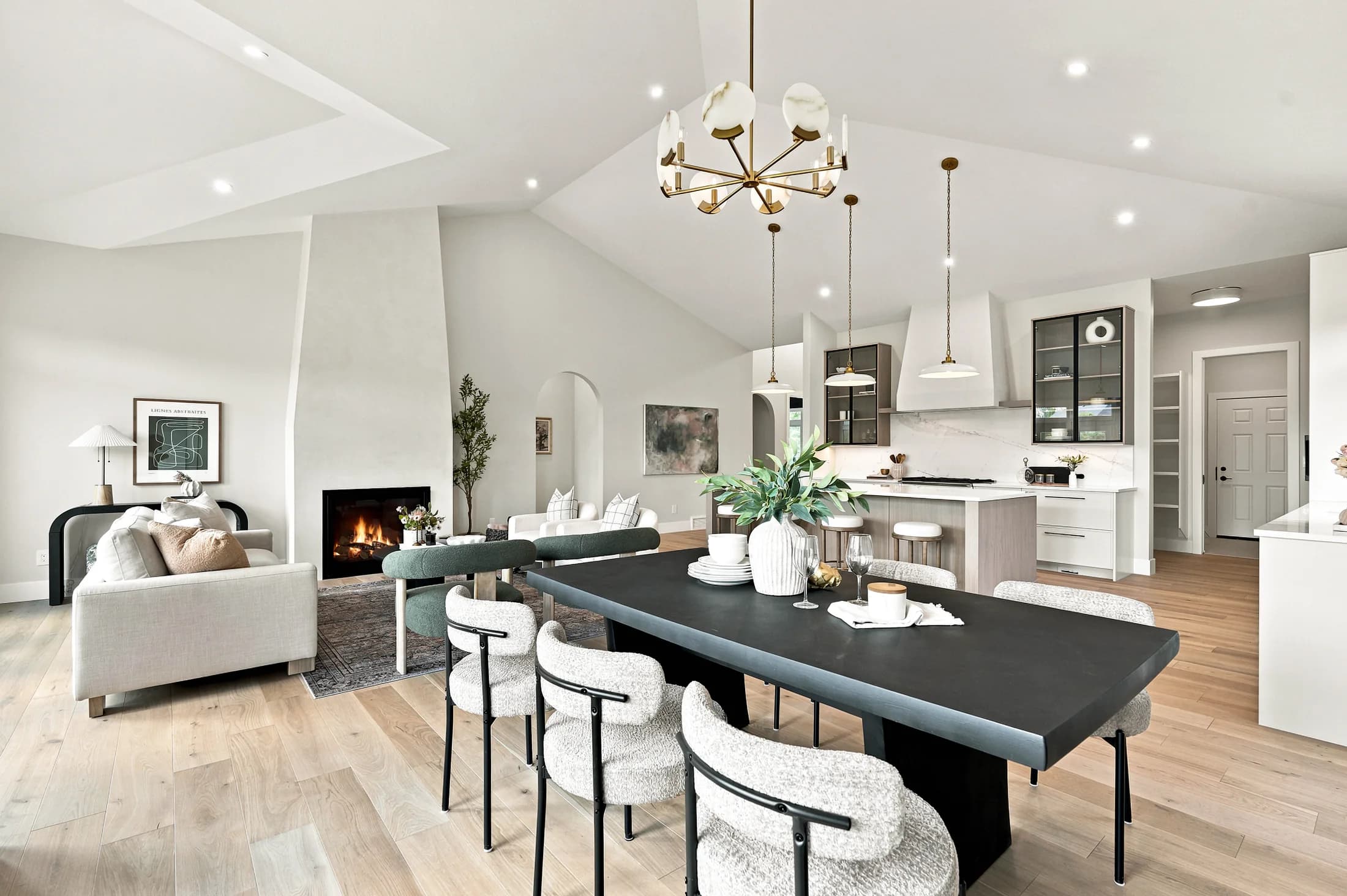 Open dining and living space with a dark dining table and fireplace